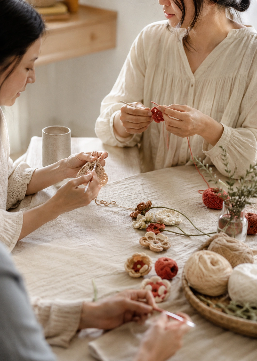 Hands creating crochet together in warm natural light